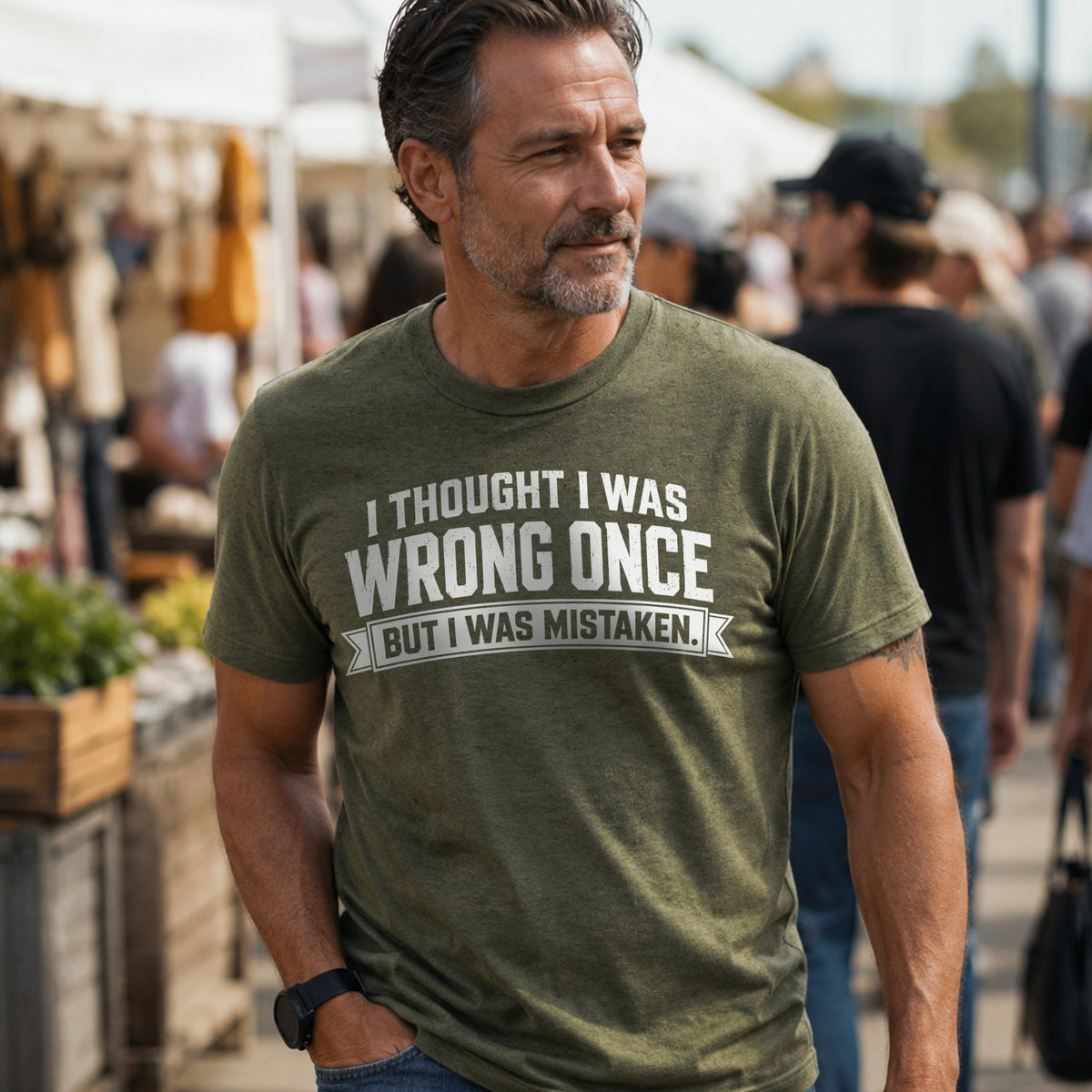 Man wearing I Thought I Was Wrong Once But I Was Mistaken heather military green T-shirt outdoors